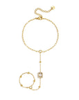 Goudkleurige stainless steel hand chain met heldere steentjes en rechthoekige steen