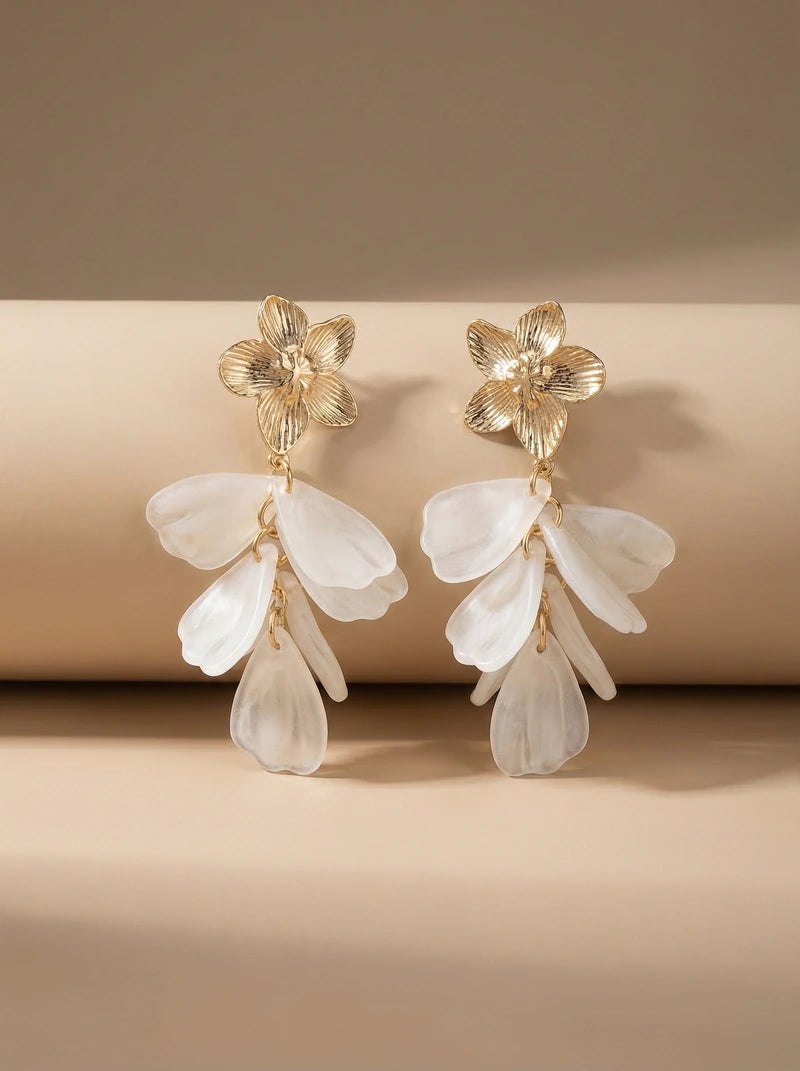 Dreamy Blossom oorbellen met goudkleurige bloem, grote witte hangende bloemblaadjes en stainless steel oorstekers.