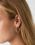 Goudkleurige stainless steel oorringen met ronde strass steentjes rondom, 2,9 x 2,9 cm.