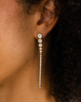 Lange goudkleurige stainless steel oorbellen van 7 cm met ronde strass steentjes en twee smalle hangende slierten