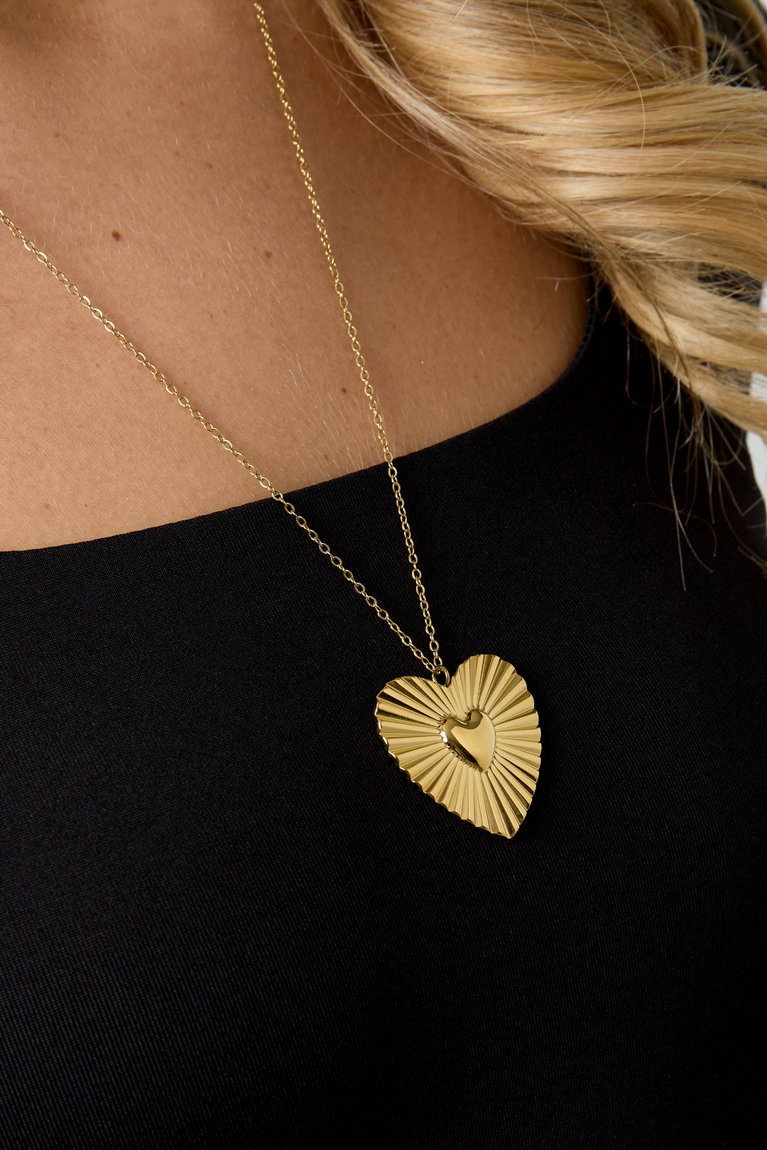 Goudkleurige lange stainless steel ketting met groot stralend hart en klein hartje in het midden