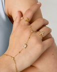 Goudkleurige stainless steel hand chain met heldere steentjes en rechthoekige steen